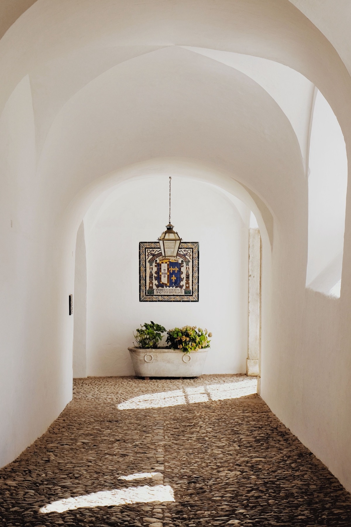 Couloir voûté d’une demeure portugaise, azulejos et sol pavé de galets